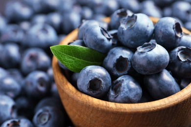 Photo of Tasty fresh blueberries and bowl, closeup view