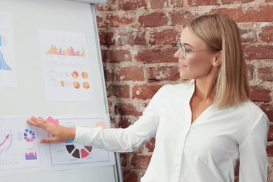 Photo of Businesswoman near flipchart board in office. Lady boss