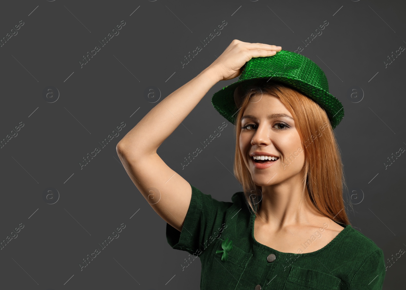 Photo of Young woman in green outfit on grey background, space for text. St. Patrick's Day celebration