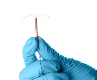 Gynecologist holding copper intrauterine contraceptive device on white background, closeup