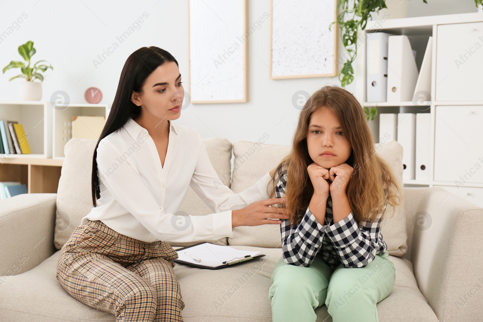 Photo of Young psychologist working with teenage girl in office