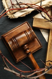 Judge gavel, wooden cross and crown of thorns on black table, flat lay