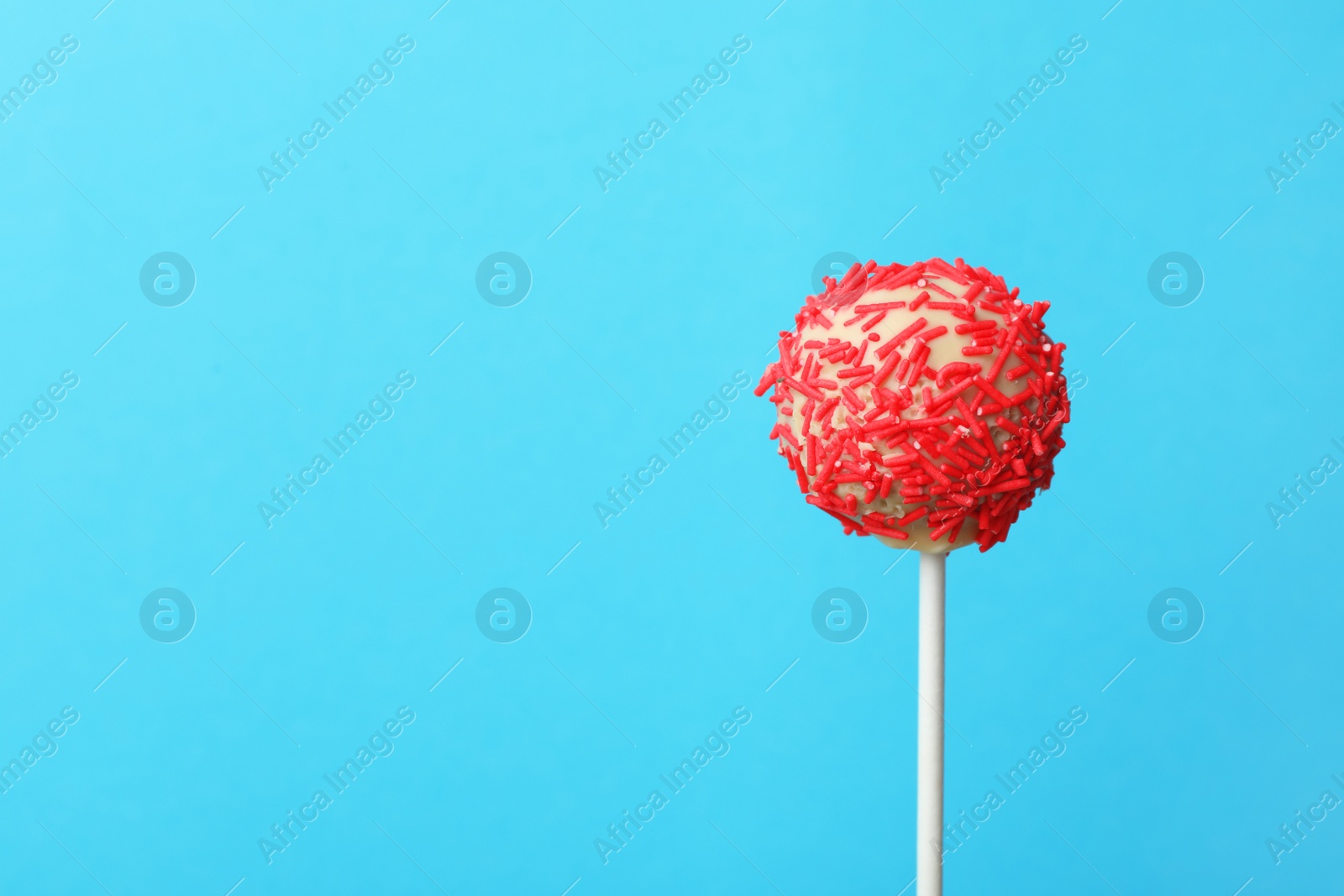 Photo of Yummy bright cake pop on color background. Space for text