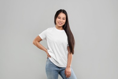 Photo of Woman wearing white t-shirt on light grey background