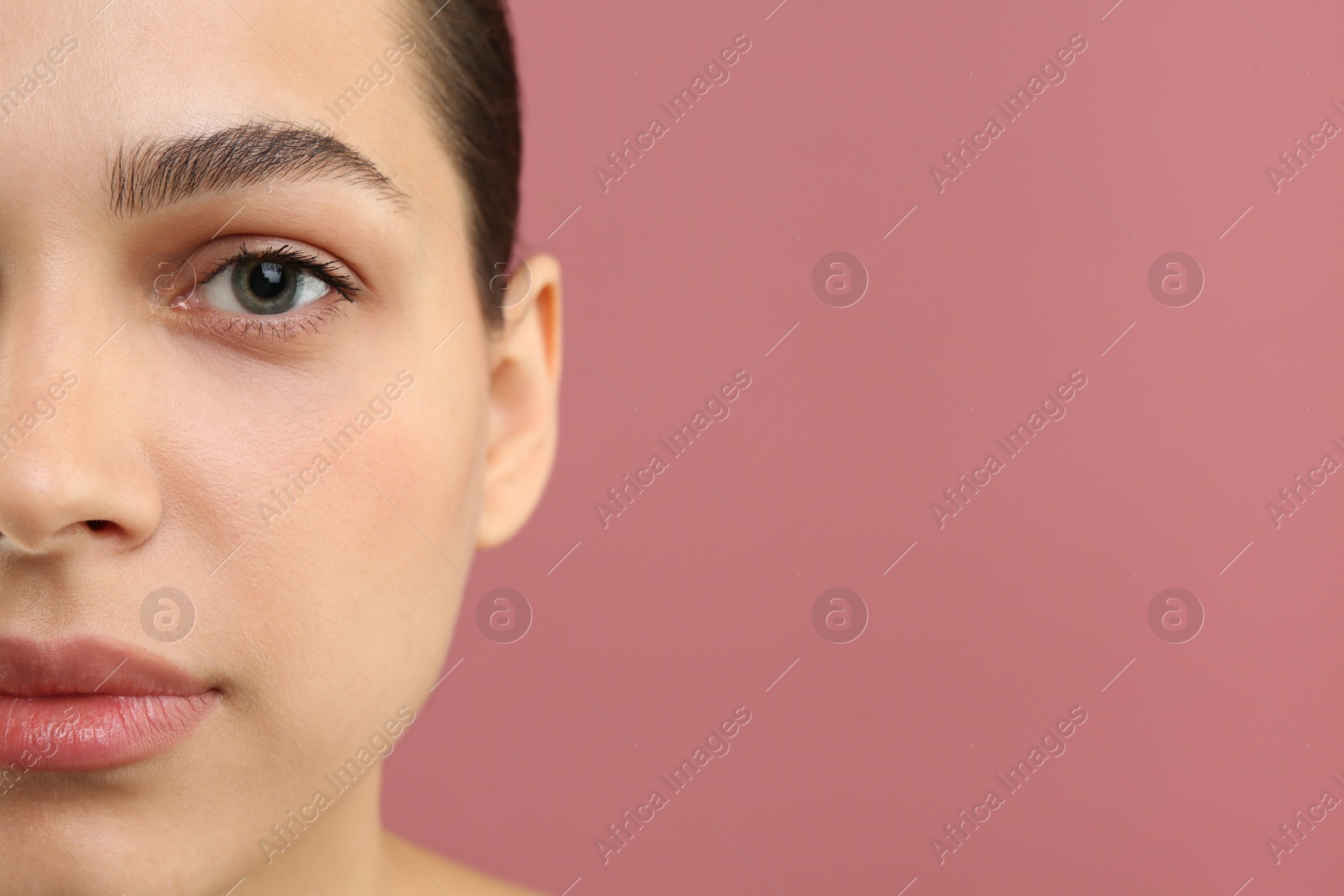 Photo of Young woman with perfect eyebrows on pink background, closeup. Space for text