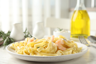 Photo of Delicious pasta with shrimps on white wooden table