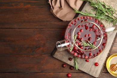 Photo of Tasty hot cranberry tea on wooden table, flat lay. Space for text