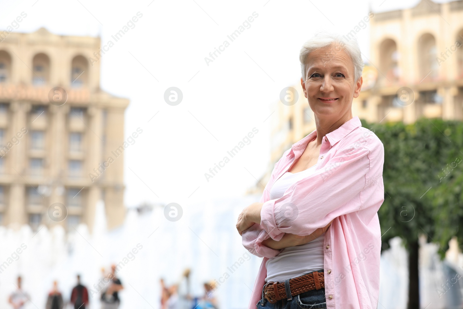 Photo of Happy mature woman on city street, space for text. Smart aging