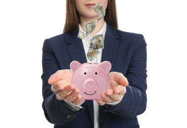 Young woman and American dollars falling into piggy bank on white background, closeup 