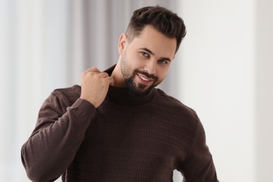 Photo of Happy man in stylish sweater against blurred background