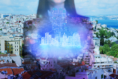 Image of Young woman holding virtual image of city, closeup. Modern technology
