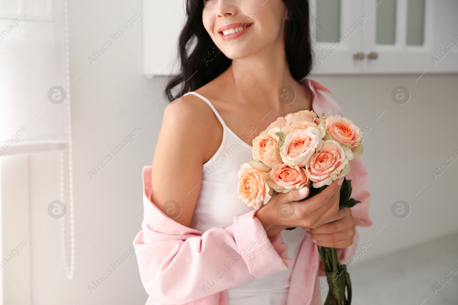 Photo of Young woman with beautiful bouquet in kitchen, closeup