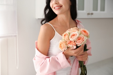 Young woman with beautiful bouquet in kitchen, closeup