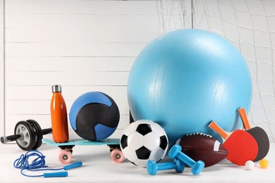 Many different sports equipment on white table