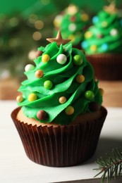 Photo of Tasty Christmas cupcake on white table, closeup