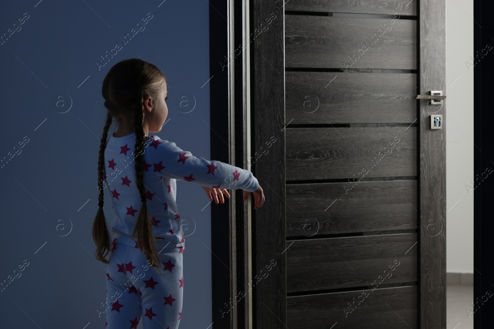 Photo of Girl in pajamas sleepwalking indoors at night