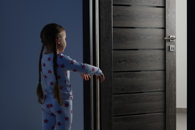 Girl in pajamas sleepwalking indoors at night