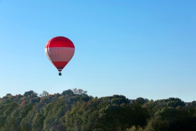Photo of Beautiful viewhot air balloon flying over autumn forest. Space for text
