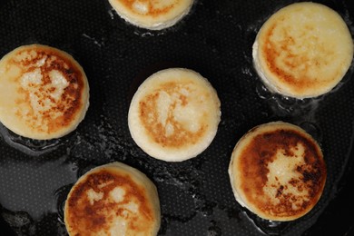 Photo of Delicious cottage cheese pancakes in frying pan, flat lay