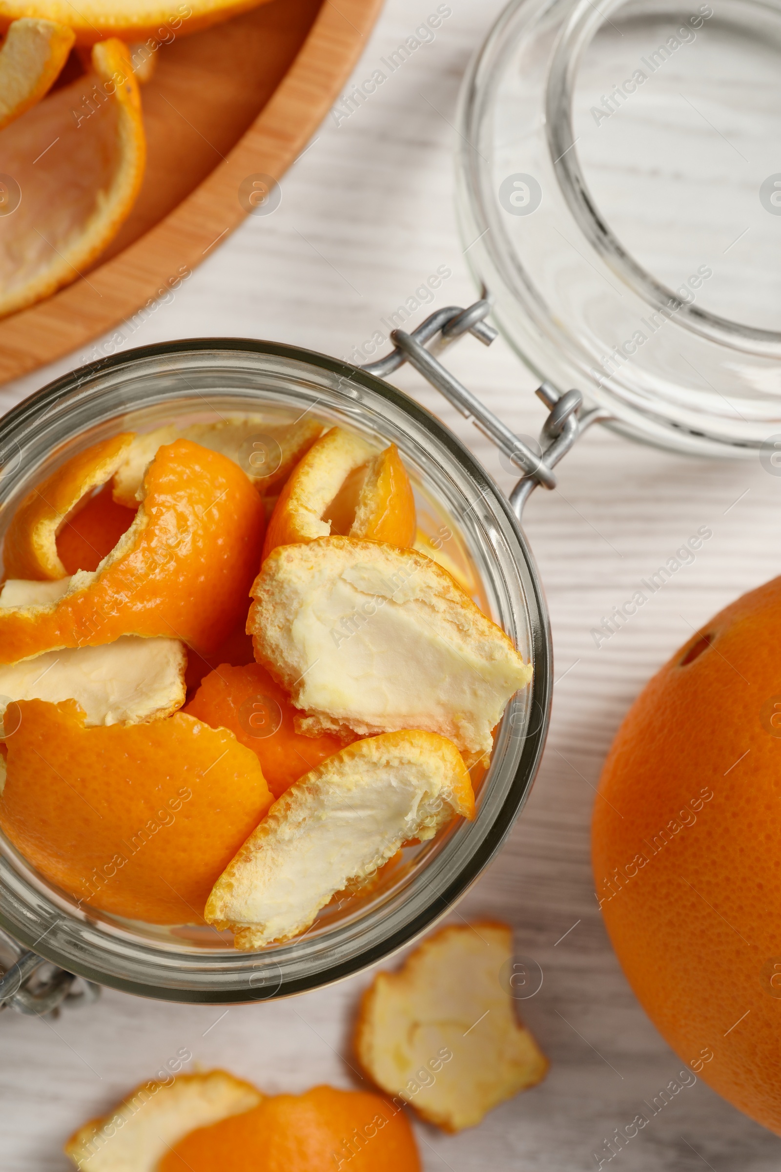 Photo of Orange peels preparing for drying and fresh fruit on white wooden table, flat lay