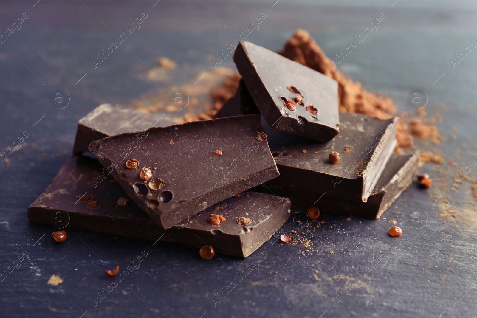 Photo of Pieces of delicious dark chocolate on table