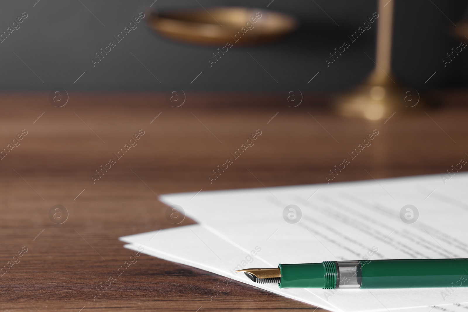 Photo of Fountain pen and paper documents on wooden table, closeup with space for text. Notary service