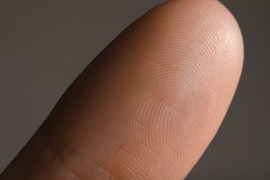 Photo of Closeup view of human finger on grey background