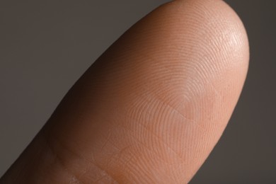 Closeup view of human finger on grey background