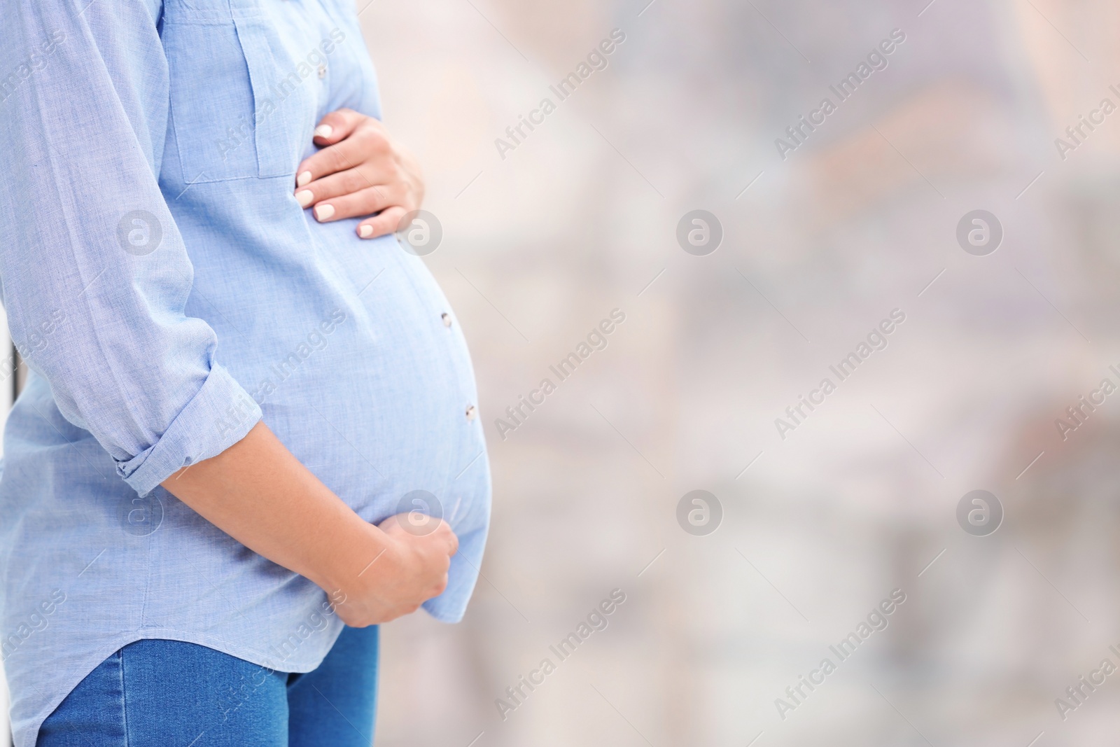 Photo of Beautiful pregnant woman near window at home