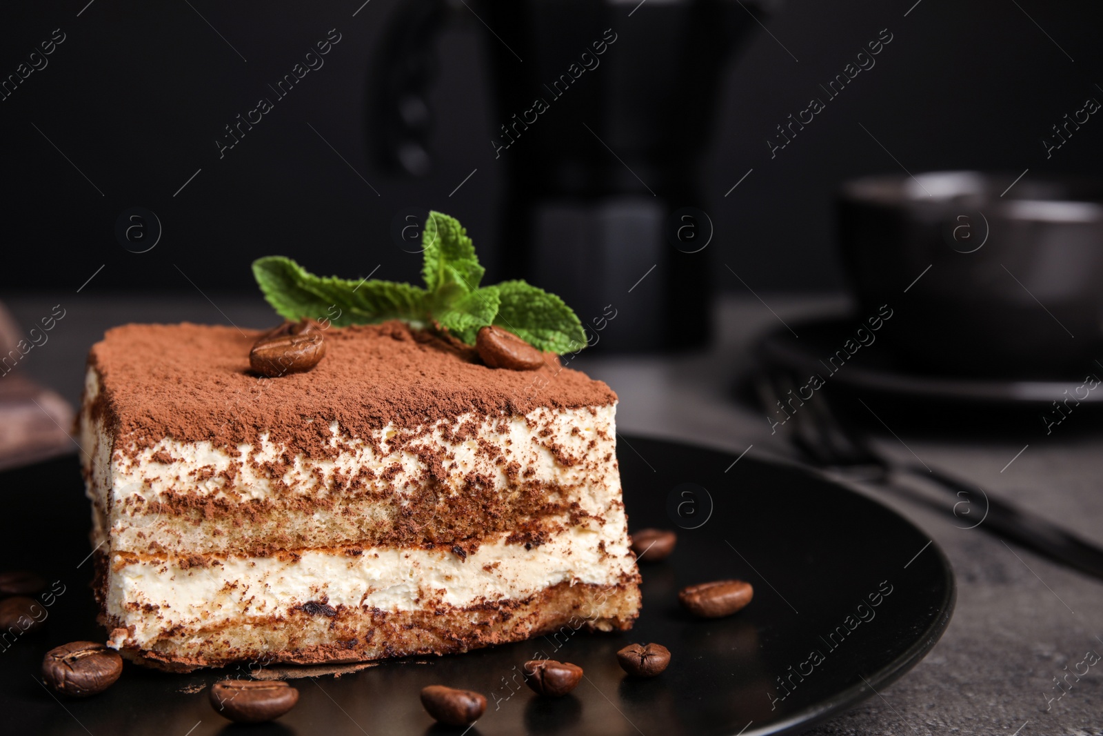 Photo of Composition with tiramisu cake on table against dark background, closeup. Space for text