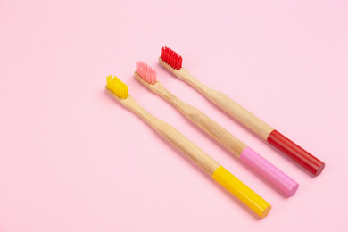 Photo of Toothbrushes made of bamboo on pink background