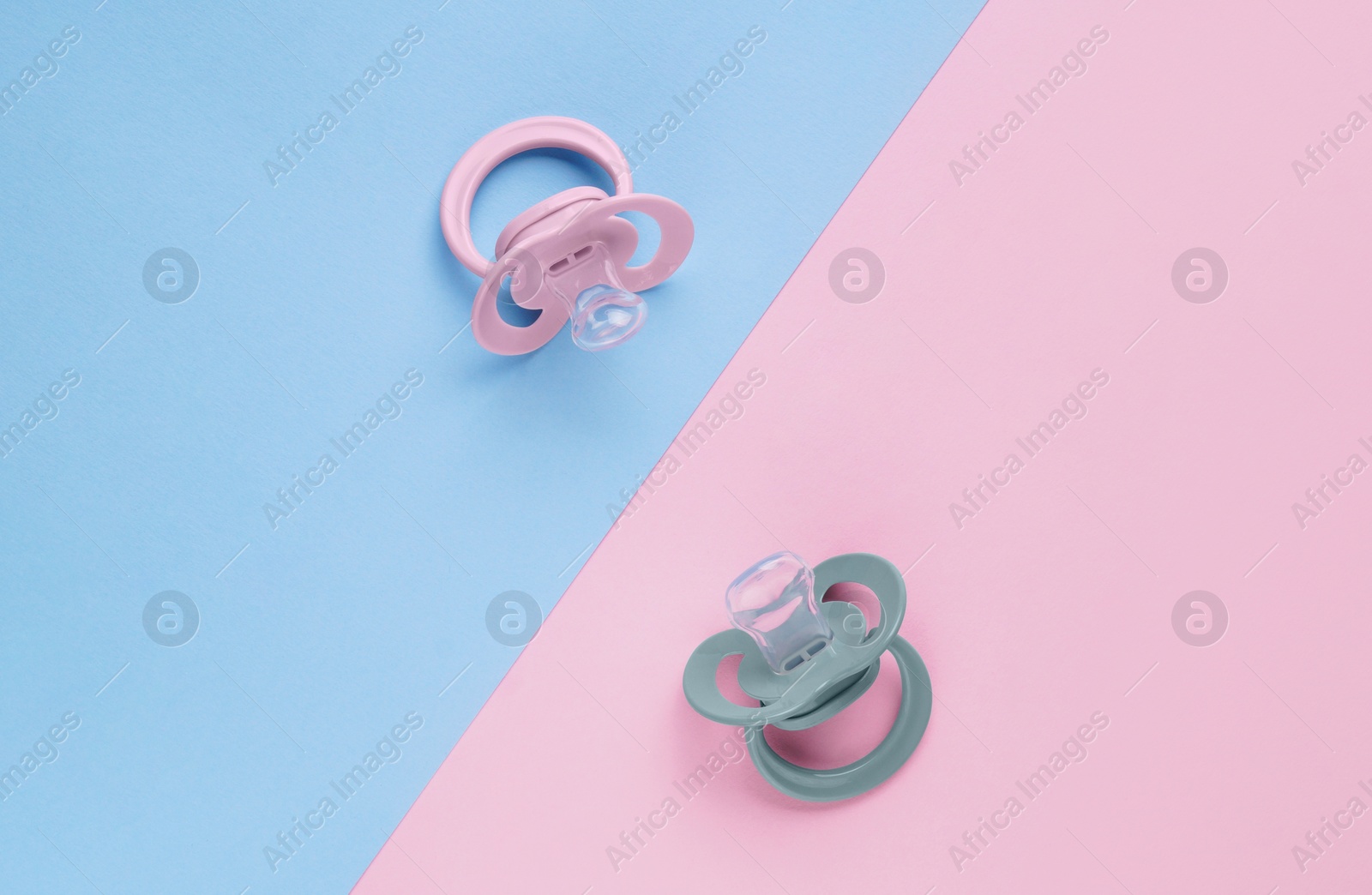 Photo of New baby pacifiers on color background, flat lay