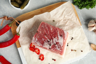 Photo of Flat lay composition with pork fatback and spices on grey table, top view