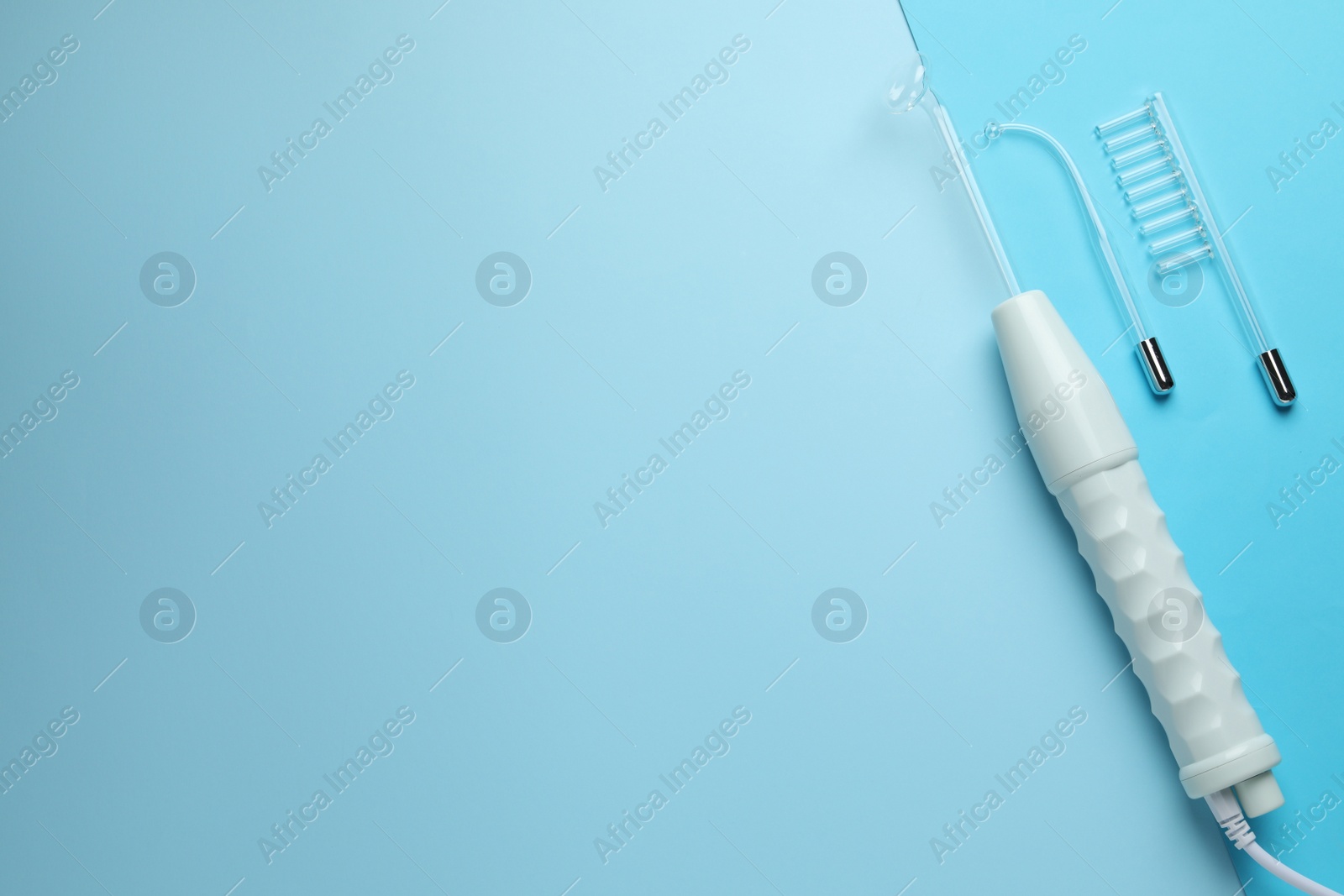 Photo of Darsonval and different nozzles on light blue background. Space for text