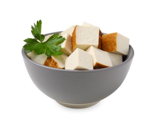 Photo of Bowl of delicious smoked tofu cubes with parsley isolated on white