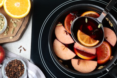 Photo of Delicious hot mulled wine on stove, top view