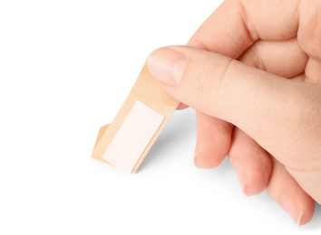 Photo of Woman putting sticking plaster on white background. First aid item