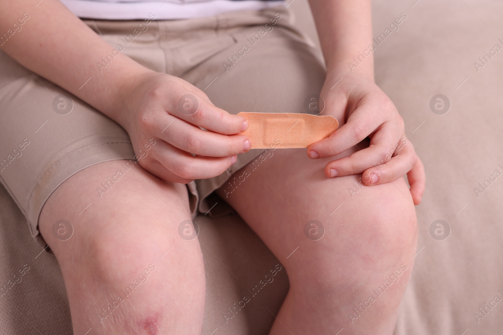 Photo of Little boy with sticking tape on sofa, closeup