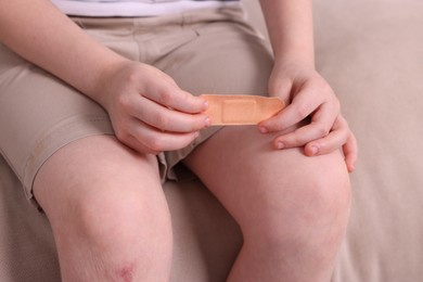 Photo of Little boy with sticking tape on sofa, closeup