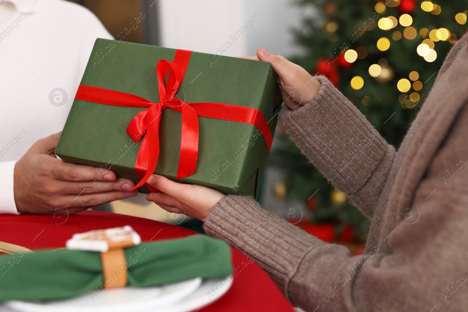 Photo of Woman receiving Christmas gift from her boyfriend at home, closeup