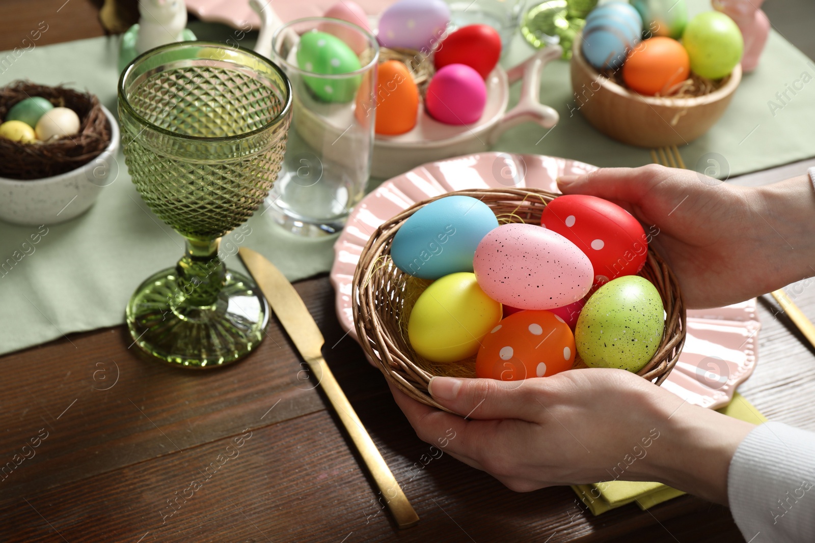 Photo of Woman setting table for festive Easter dinner at home, closeup