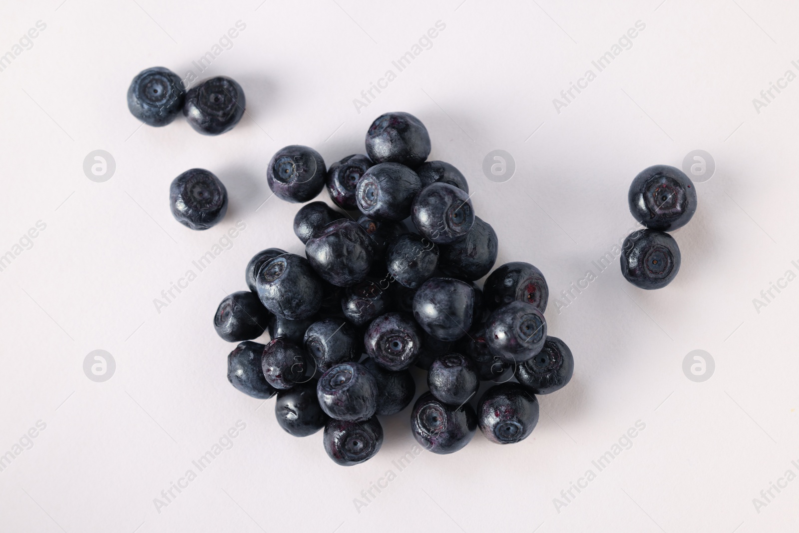 Photo of Pile of ripe bilberries on white background, flat lay