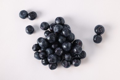 Photo of Pile of ripe bilberries on white background, flat lay