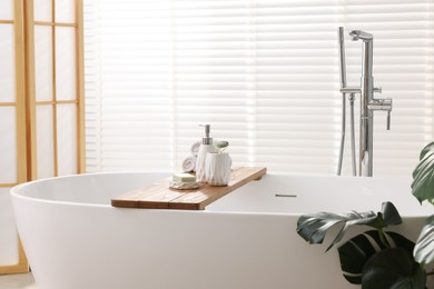 Different personal care products on bath tub in bathroom