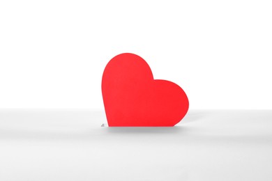 Photo of Red heart into slot of donation box against white background