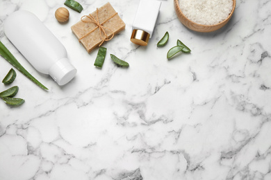 Photo of Flat lay composition with aloe vera and cosmetic products on white marble background. Space for text