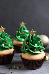 Christmas tree shaped cupcakes on grey board