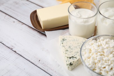 Photo of Different fresh dairy products on white wooden table, closeup. Space for text