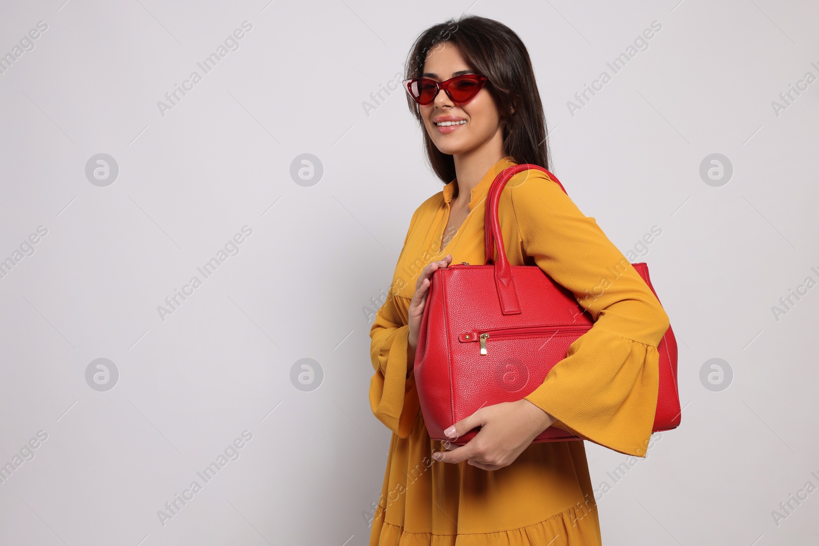 Photo of Young woman with stylish bag on white background, space for text