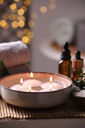 Beautiful composition with different spa products on table against blurred lights